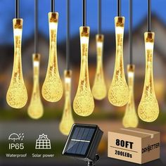 the solar powered water droplet lights are hanging in front of a box and some other items