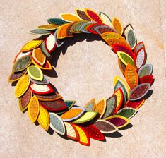 a colorful wreath made out of leaves on the ground