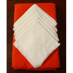 six napkins folded on top of each other with white and red border around them