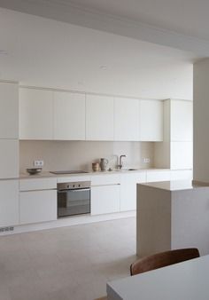 an empty kitchen with white cabinets and counters