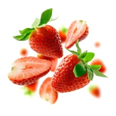 three strawberries with green leaves on them are floating in the air against a white background