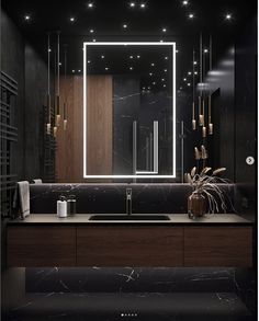 a bathroom with a sink, mirror and lights on the wall above it's counter