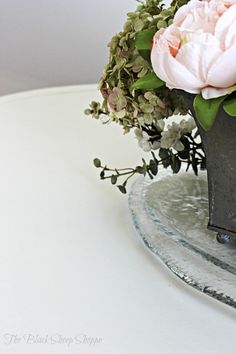 a vase filled with flowers sitting on top of a glass plate