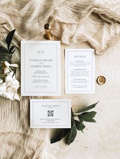 the wedding stationery is laid out on top of an unmade bed with flowers and greenery