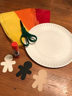 paper plate cutouts and scissors on a wooden table