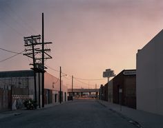 the sun is setting on an empty street