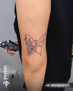 a woman's arm with flowers and a butterfly tattoo on the left side of her arm