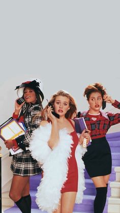 three women dressed in costumes standing on stairs