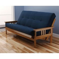 a blue futon couch sitting on top of a hard wood floor