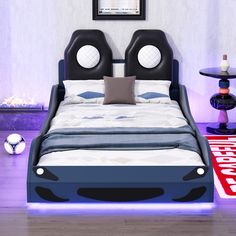 a bed with two headboards on each side and pillows on the bottom, in front of a purple wall