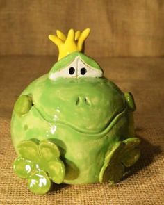 a ceramic frog with a crown on its head