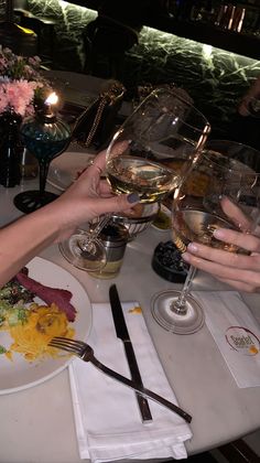 two people are toasting with glasses of wine