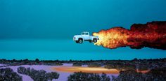 a truck is flying through the air with fire coming out of it