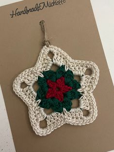 a crocheted christmas ornament hanging on a card