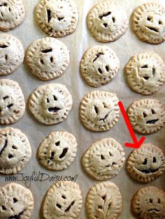 there are many small pies with faces drawn on them and one has a red marker in the middle