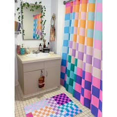 a bathroom with a colorful shower curtain next to a sink