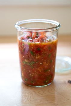 a glass jar filled with food sitting on top of a wooden table