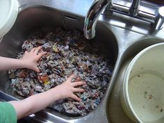 a child washing their hands in a sink full of garbage