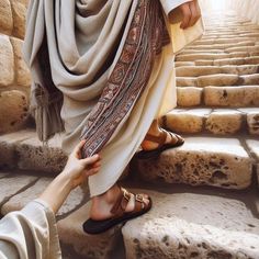 a woman is walking up some steps with her foot on another person's hand