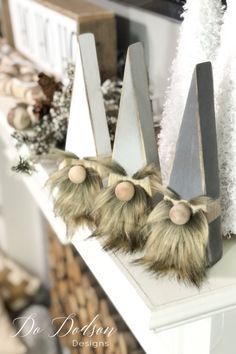 three pieces of wood with fake fur on them sitting on top of a fireplace mantel