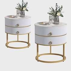 two white and gold side tables with vases on each end, one holding flowers