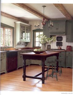 an old fashioned kitchen with wood floors and green cabinets