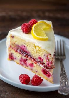 a piece of cake on a plate with raspberries