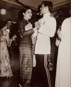 an old black and white photo of two people in formal wear dancing with each other