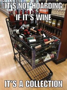 a shopping cart filled with lots of bottles and wine in the middle of a store