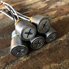 four silver batteries on top of a wooden table with wires attached to the ends,