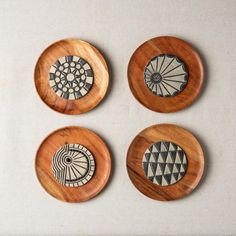 four small wooden plates with designs on them