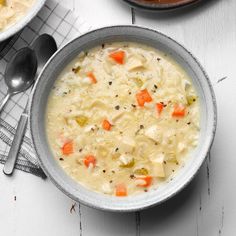 two bowls filled with soup on top of a white table