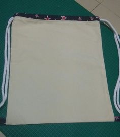 a drawstring bag sitting on top of a green mat covered in white string