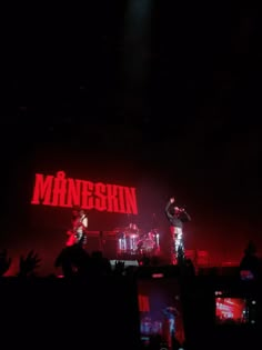 two people on stage with the words minnesota projected in the dark behind them and red lighting