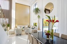 a living room filled with furniture and a large black table surrounded by white couches