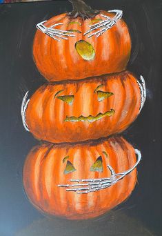 three pumpkins sitting on top of each other in front of a black background with white writing