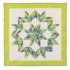 a green and white quilt with a large star design on it's center piece