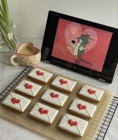 there are many decorated cookies on the table next to a vase with tulips