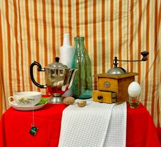 a table topped with different types of kitchen utensils and other items on top of a red cloth