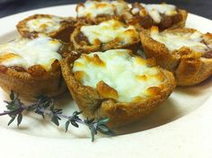 several mini pizzas on a plate with some sprig of thyling next to them