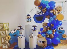 an assortment of cookie cookies and balloons on display in a room with blue carpeted flooring