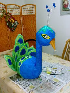 a stuffed peacock sitting on top of a table