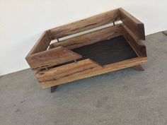 a wooden bench sitting on top of a cement floor