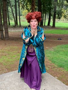 a woman dressed as merida from brave in the woods with her hands clasped to her chest