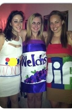 three women in dresses are posing for the camera