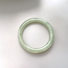 On offer is this beautiful Vintage Chinese 1960's Hand Carved Translucent Celadon Green Nephrite Jade Bangle featuring tiny emerald green color veins within the Nephrite Jade which can be seen because the Nephrite is so transparent. Genuine undyed Nephrite Jade which is 10 mm wide and has 7.514 inches inner circumference. In very good vintage condition with no damage or repairs because it is old stock that has never been worn.  Weight 39.2 grams. The Nephrite Jade has achieved a lovely pearly ag Classic Green Jade Jewelry, Green Classic Bangle For Formal Occasions, Classic Jade Bracelets For Formal Occasions, Elegant Green Round Bangle, Classic Green Bangle Jewelry, Handmade Green Jade Bangle, Green Bangle Bracelet For Formal Occasions, Green Bangle Bracelets For Formal Occasions, Formal Green Bangle Bracelets