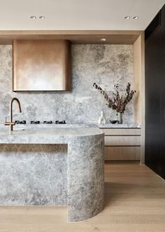 a modern kitchen with marble counter tops and stainless steel faucets, along with wooden cabinets