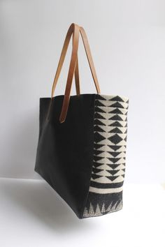 a black and white tote bag sitting on top of a table