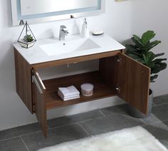 a bathroom vanity with a mirror above it and a white rug on the floor next to it