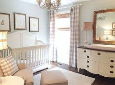 a baby's room with a crib, dresser, and mirror in it